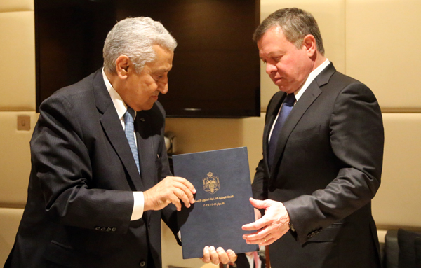 His Majesty King Abdullah receives a copy of a plan to enhance the human rights situation in Jordan, delivered by Prime Minister Abdullah Ensour, on Wednesday (Photo courtesy of Royal Court)